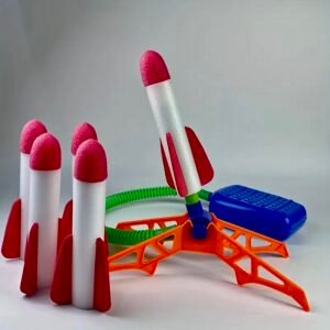 A colorful foam rocket launcher set featuring a foot-powered pump, launch tube, and soft-tipped PE foam rockets in mixed colors.