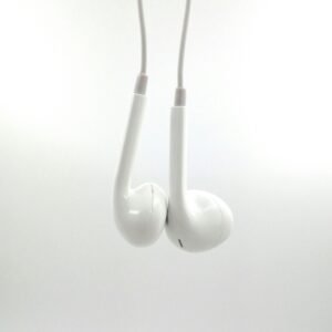 Simple close-up of white earphones suspended against a blank backdrop.