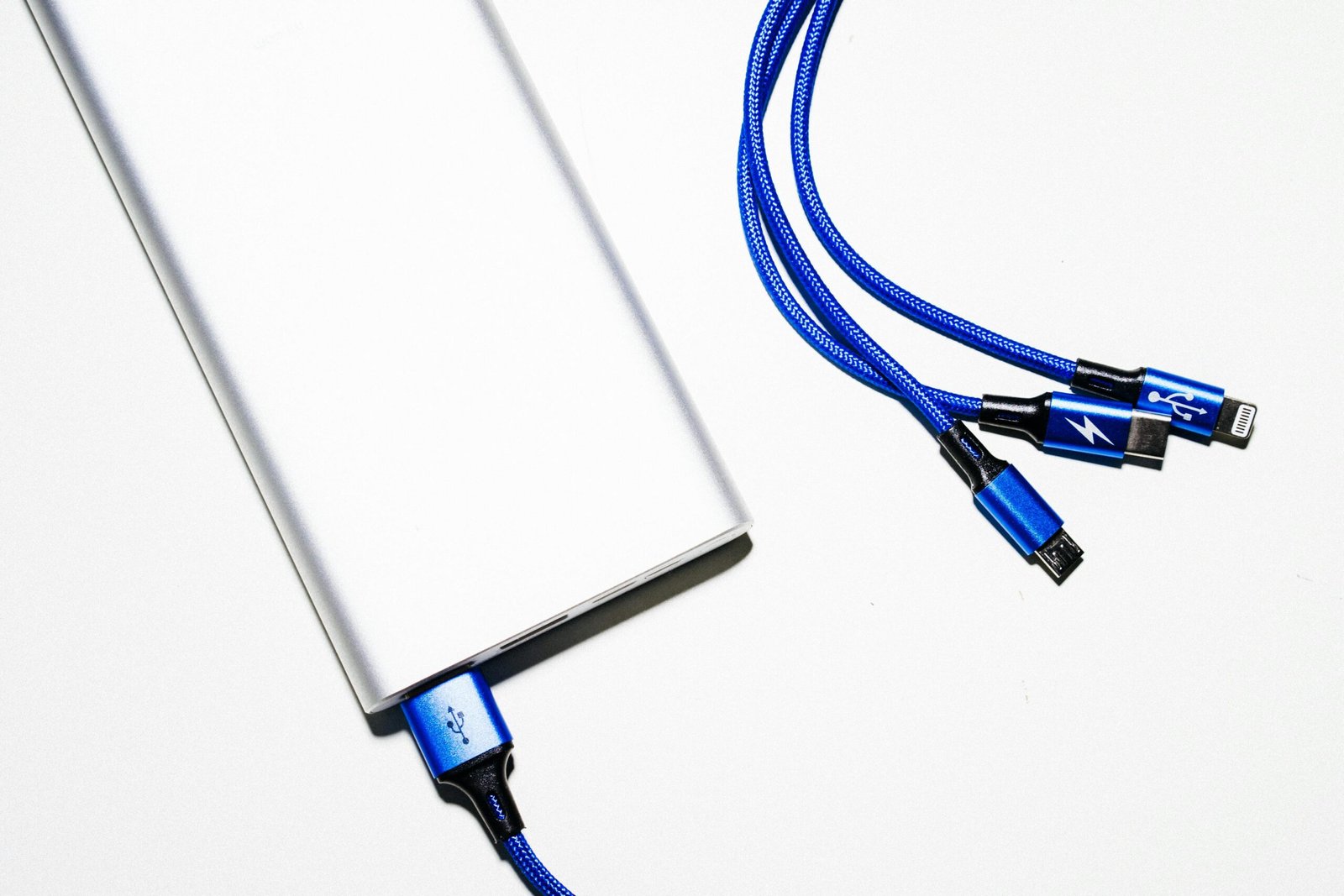 pexels photo 4072683 4072683 Minimalist image of a power bank with blue USB charging cables on a white background.