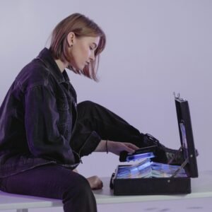 A woman examining cash in a briefcase, hinting at modern financial themes indoors.