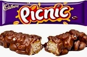 A Nestlé Picnic chocolate bar featuring the signature irregular shape packed with peanuts, raisins, wafer, and caramel, coated in milk chocolate.