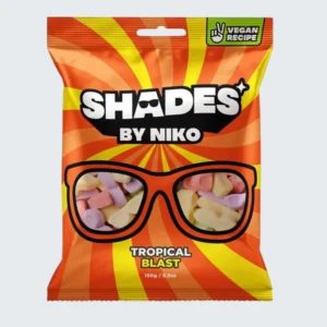 Front view of a 150g sharing bag of Shades by Niko 'Tropical Blast' foam sweets. The vibrant, exotic packaging features the classic 'Shades' mascot in sunglasses, colorful tropical theme designs, and clear badges indicating it is 100% Vegan and Halal Europe certified