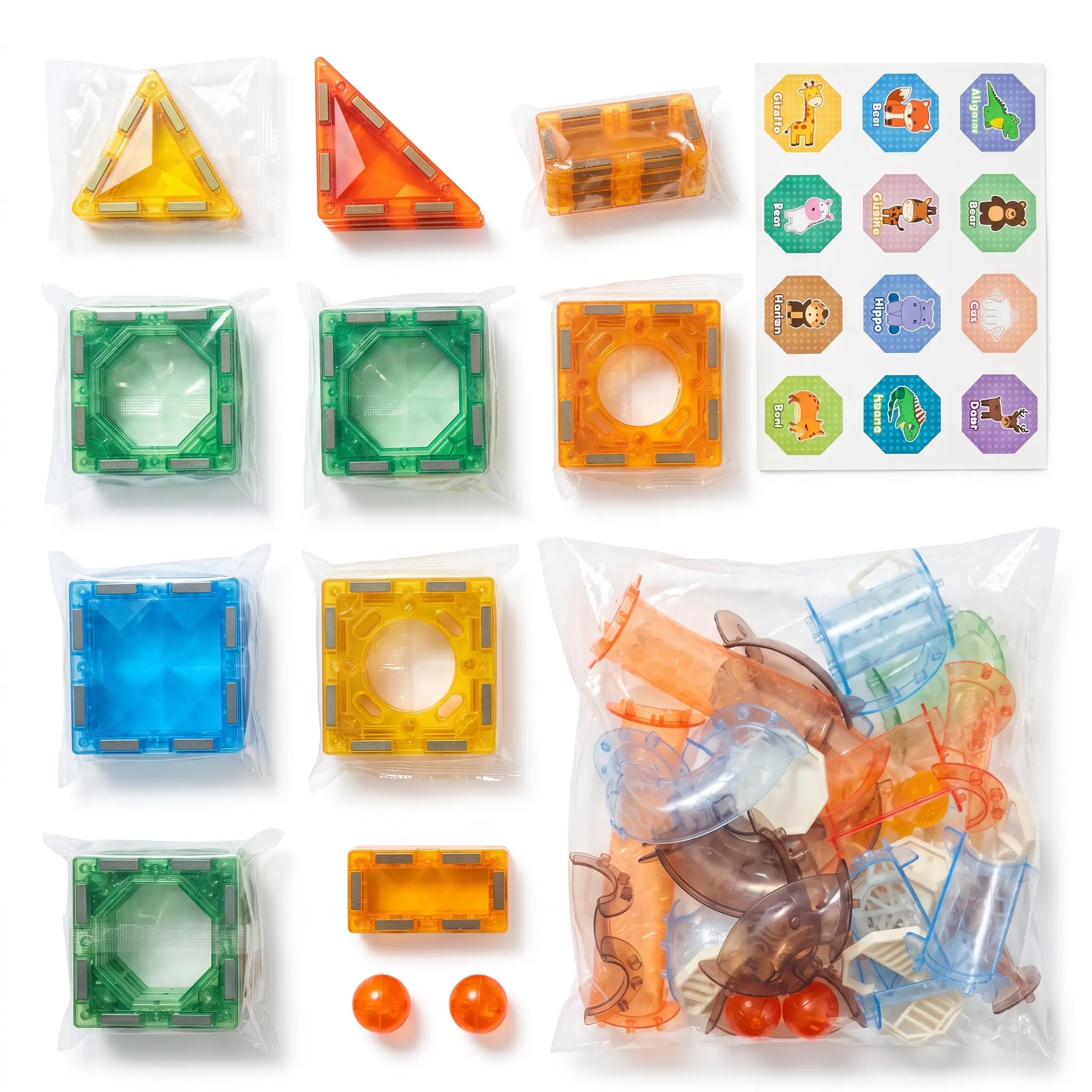 Complete contents of the 68-piece magnetic marble run set showing geometric tiles, tube slide pieces, stickers, and rolling balls